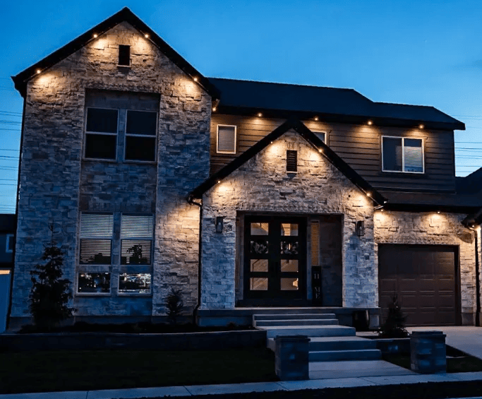 Home with warm white permanent accent lighting along the roofline at dusk
